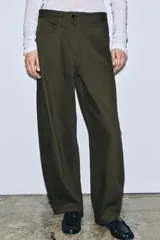 Pantalón de mujer color verde militar, estilo balloon o ancho, con tiro alto, cinco bolsillos y cierre frontal con cremallera y botón.