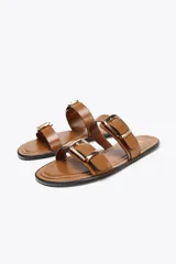Sandalias planas color marrón con doble tira y hebillas doradas.