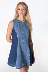 Vestido corto de denim en silueta A, sin mangas y con ruedo amplio. Contiene pinzas para marcar la figura y un cierre largo en la espalda.