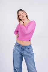 Remera corta de tejido de punto acanalado color fucsia, con escote cuadrado y mangas largas.