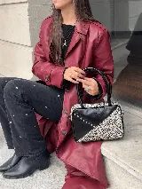 Cartera rígida negra de cuero con tachas plateadas y tres combinaciones de cuero diferentes que aportan textura. Tiene herrajes y cierre metálico plateado marca YKK. Cuenta con un asa fina para llevar al hombro o en la mano y una correa larga extra regulable.