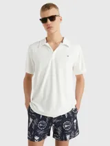 Chomba blanca de felpa de Tommy Hilfiger con cuello clásico, corte amplio, logo bordado en el pecho y detalles distintivos de la marca.