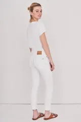 Pantalón jean blanco de corte slim, tiro alto y terminación desflecada en el ruedo.