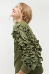 Remera negra de punto con mangas largas abullonadas con volantes.