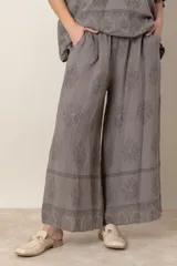 Pantalón palazzo de lino color crudo con estampado floral al tono, tiro alto y cintura elastizada.