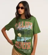 Remera verde militar de algodón con cuello redondo y mangas cortas. Estampado frontal con palmeras, olas y texto "Califa Hour".