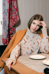 Sweater beige de cuello alto con diseño de iconos en marrón y celeste.