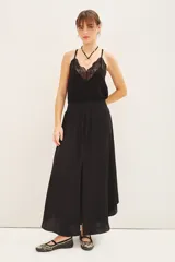 Falda midi negra con tajo lateral, breteles finos y escote en V con encaje.