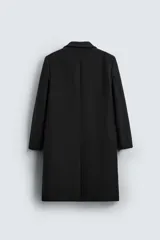 Abrigo negro regular fit confeccionado en paño con lana. Tiene cuello con solapas de muesca, manga larga, bolsillos de solapa en la cadera, bolsillo interior, abertura en el centro de la espalda y cierre frontal con botonadura.