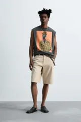 Camiseta sin mangas gris oscuro de corte holgado, con cuello redondo y estampado frontal de un hombre con sombrero y camisa floreada. Diseño de la colaboración especial Zara x Otis Kwame Kye Quaicoe.