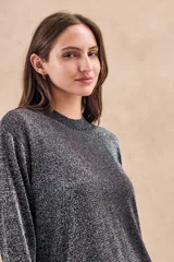 Sweater negro texturado de lurex, con calce al cuerpo y mangas largas.
