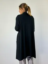 Saco tejido de largo medio color negro, con bolsillos laterales y corte holgado.