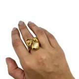 Anillo de acero dorado con aplique de nácar y cristal.