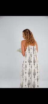 Vestido largo de tirantes color crudo con estampado de arabescos en negro, corte suelto y elástico en la parte superior.