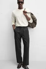 Pantalón negro regular fit confeccionado en tejido de lino. Cintura ajustable con cordón interior, bolsillos frontales y detalle de bolsillos traseros de vivo.