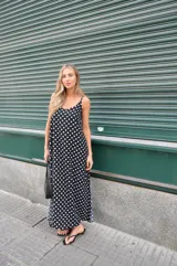 Vestido largo negro con estampado de lunares blancos, breteles finos y escote en V.