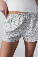 Conjunto de pijama corto blanco, compuesto por una remera de algodón con estampado de texto en el pecho y un short con estampado de corazones.
