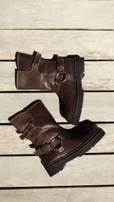 Bota de cuero color chocolate con hebillas metálicas y suela track.