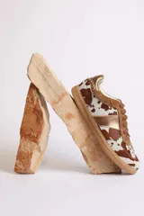 Zapatillas deportivas bajas con estampado animal print de vaca en blanco y marrón.