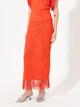 Pollera larga tejida color naranja, de corte ajustado y calados.