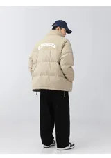 Campera puffer color beige con parte superior de pana, bordado en la espalda y tiras regulables en la cintura.