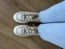 Zapatillas de lona blancas de caña alta con cordones y puntera de goma. Logo de durazno engomado en la base y en la cara interna.