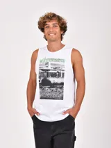 Musculosa blanca de cuello redondo y sisa amplia, con un estampado frontal de estilo fotográfico en blanco y negro que muestra un paisaje desértico y una construcción, acompañado por la palabra "wilderness" en color verde.