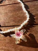 Collar de perlas cultivadas con dije de estrella de mar acrílica transparente con detalles en rosa, rojo, amarillo y verde.