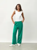 Pantalón blanco de corte ancho con una fina línea negra vertical en los laterales.