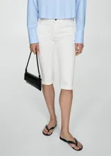 Pantalón capri de jean blanco, tiro medio, corte skinny, con cierre de cremallera y botón, trabillas, dos bolsillos delanteros y dos bolsillos traseros de parche.