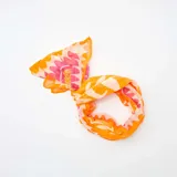 Pareo de baño rectangular con estampado de flores y ondas en tonos naranja, blanco y rosa.