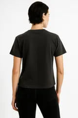 Remera de algodón color crudo con estampado de un labial rojo y texto en color bordó que dice "It's OK to wear lipstick". Corte clásico, cuello redondo y mangas cortas.