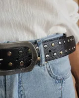 Cinto marrón de cuero con tachas plateadas y doradas, y hebilla metálica rectangular color bronce.