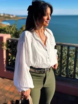 Camisa blanca de algodón con bordados florales en el cuello y el frente, corte suelto y mangas abullonadas.
