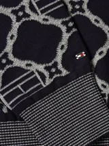 Sweater azul marino con diseño de rombos blancos con el logo de la marca en el centro. Tiene cuello redondo, puños y bajo acanalados.