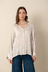 Camisa blanca con estampado de diseño bandana en tonos beige, de corte amplio, con cuello camisero y cierre frontal con botones.