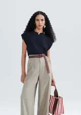 Blusa color crema de tejido acanalado, con cuello redondo y mangas cortas con hombreras.