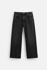 Pantalón de jean negro con corte flare y caída baggy desde la rodilla hasta el tobillo. Tiene cinco bolsillos y cierre frontal con botones.