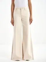 Pantalón acampanado color crema, de tiro alto, con cierre y botón. Tiene dos bolsillos delanteros y dos traseros.