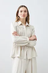 Camisa beige melange con frunces en el frente, de manga larga y cuello camisero.