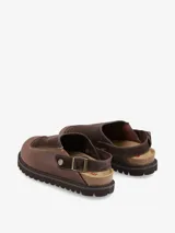 Zueco marrón de piel combinado en serraje con planta anatómica y hebilla ajustable al tobillo.