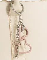 Cartera tipo tote color blanco crudo, con doble asa corta y correa larga regulable y desmontable. Incluye charm colgante con forma de corazón y cierre superior.