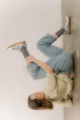 Zapatilla plateada de cuero con detalles de gamuza gris y costuras visibles.