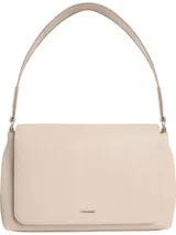 Cartera de mano Calvin Klein color beige claro, con textura de monograma en relieve. Diseño rectangular con solapa frontal de cierre magnético y correa fija para llevar al hombro. Presenta logo metálico plateado en la parte frontal.