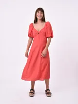 Vestido midi color salmón, con escote cuadrado, mangas cortas abullonadas y detalle de abertura en el pecho.
