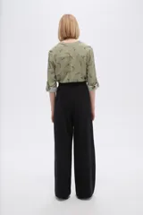Pantalón negro de corte ancho y tiro alto, confeccionado en viscosa.