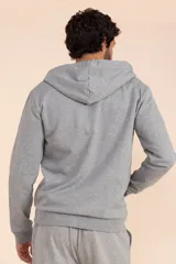 Chaqueta deportiva con capucha gris medio con cierre frontal y cordones ajustables.