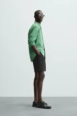 Bermuda de algodón color marrón oscuro, de corte regular fit, con cintura elástica ajustable mediante cordón. Presenta bolsillos laterales y un bolsillo trasero de vivo.