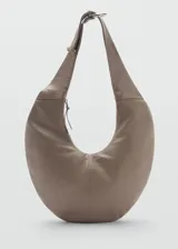 Bolso bandolera grande de cuero color gris topo, con forma de media luna y asa ajustable. Cierre superior con cremallera y forro interior de algodón.