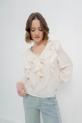 Blusa color crema con volados en el frente, detalle de puntilla y bordados florales en mangas.